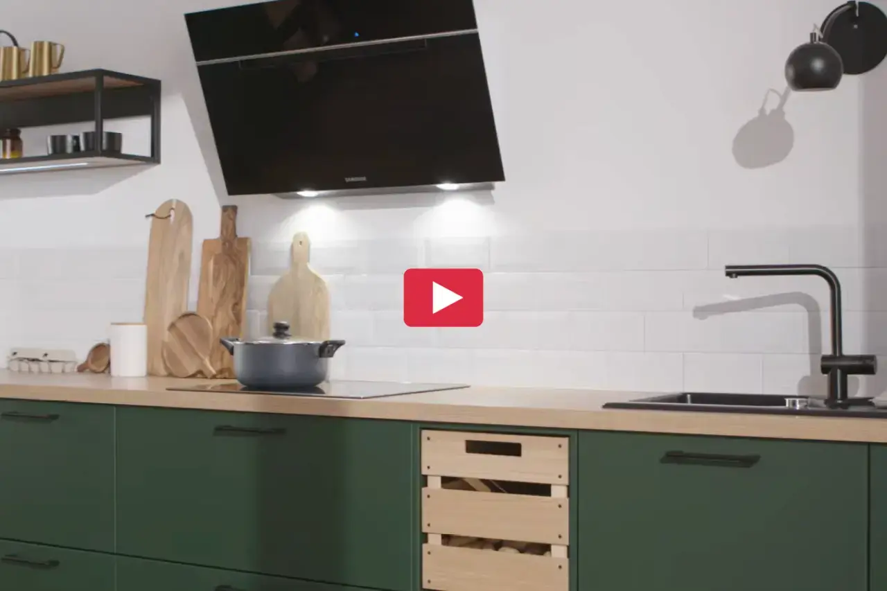 Moderne Küche mit grünen Fronten, Holzarbeitsplatte und schwarzer Dunstabzugshaube. Küchenrückwand in Fliesenoptik mit Spüle und Kochfeld. Stilvolle Einbauküche für modernes Kochen und zeitgemäßes Küchendesign.
